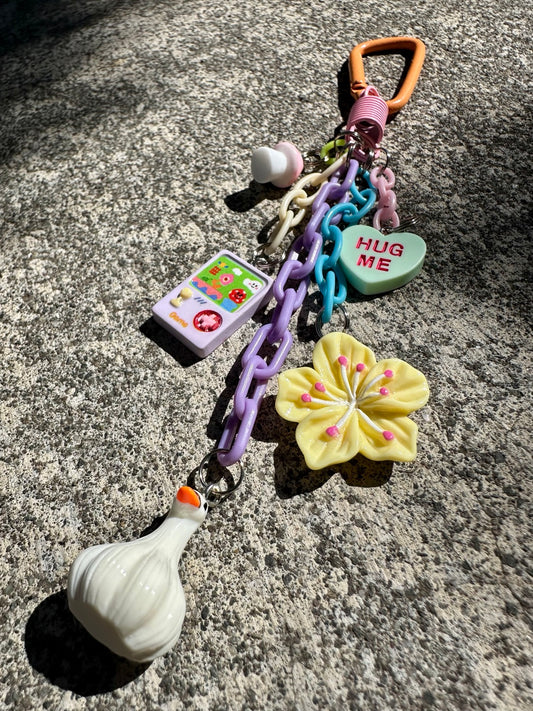 Pocket Pal bag charm angled view with five playful charms and colorful chains