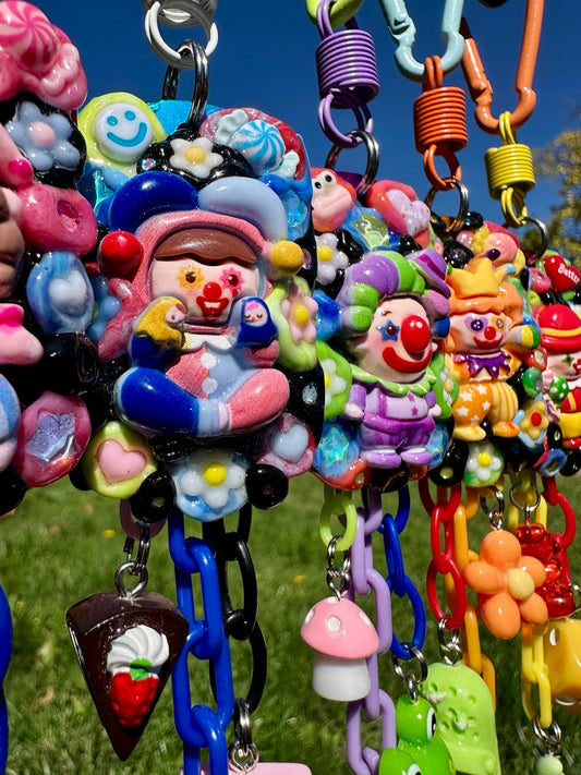 Colorful Planet HAHA clown keychain pals photographed under a bright blue sky