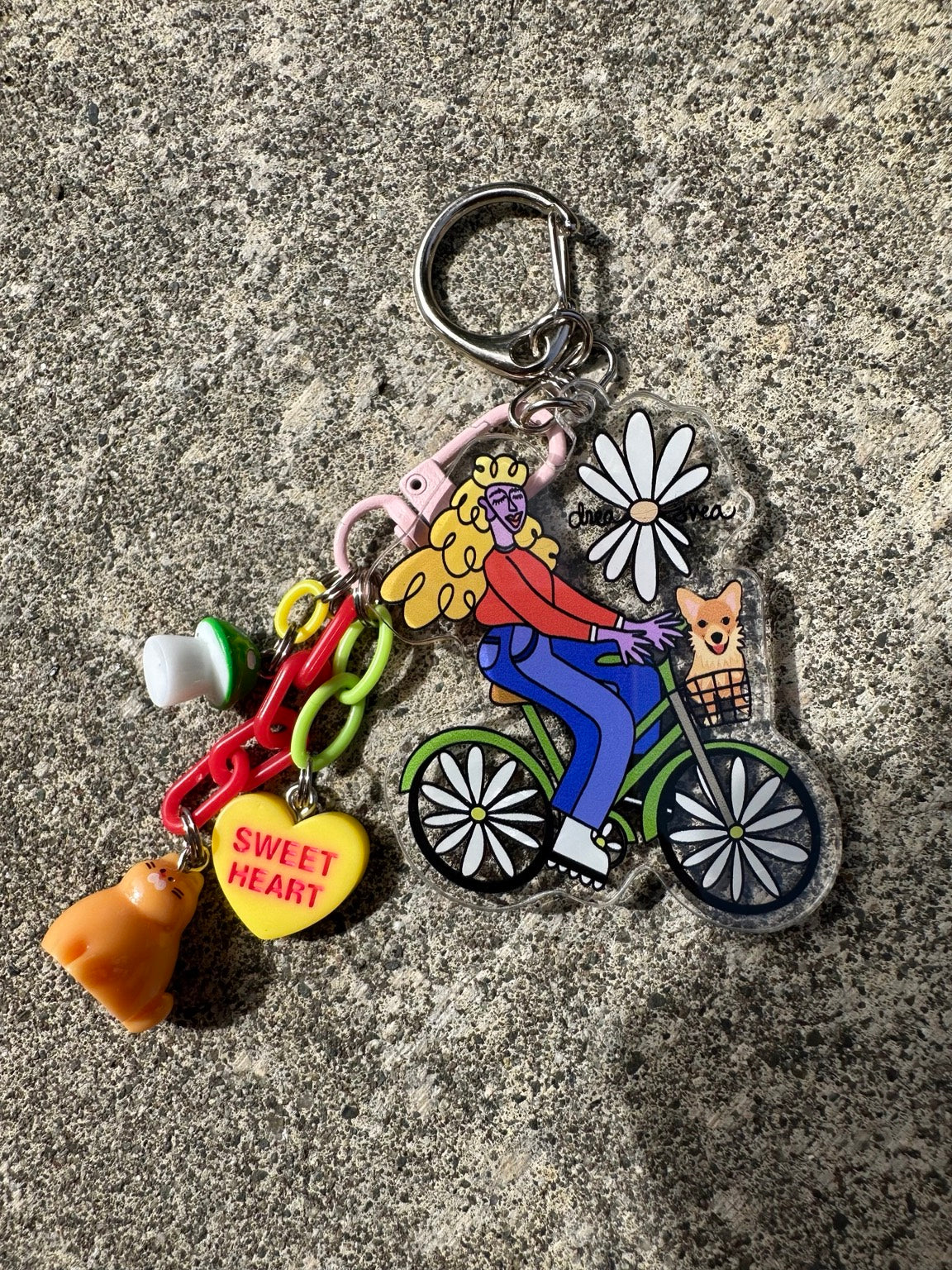 Drea Svea Bicycle Girl Pocket Pal with hand-drawn acrylic keychain, sweetheart charm and colorful dangles