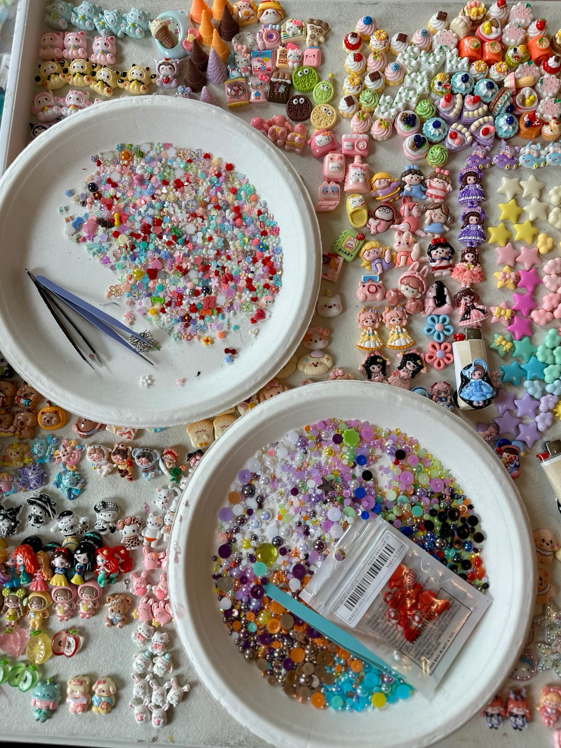 Bowls and trays of colorful tiny charms being sorted at the Drea Svea worktable