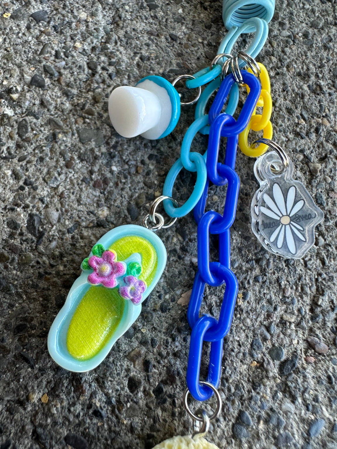 Detail of Miso's blue chain and flowered flip-flop charm