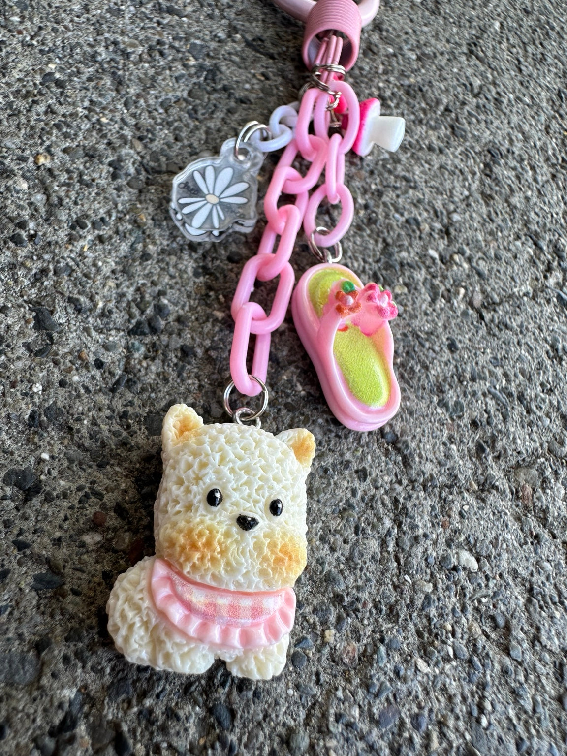 Close view of handmade Zuzu dog Pocket Pal bag charm with pink chain and flip-flop charm